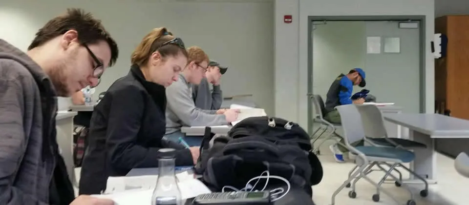 several students sitting at a table in a class