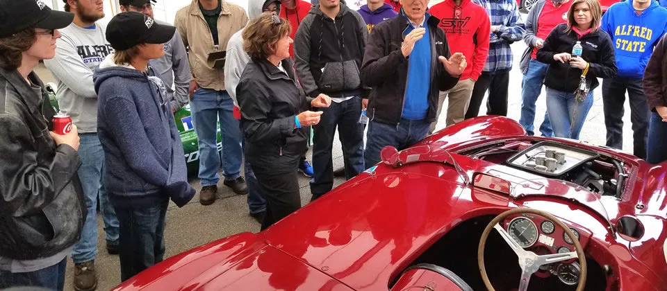 students standing around a red race car