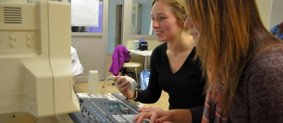 two female students in front of a sonography machine