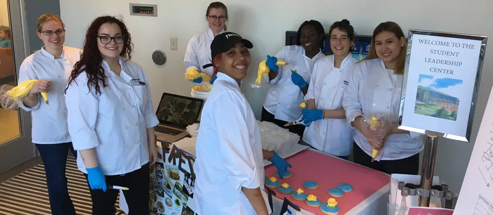 students frosting cookies at a table