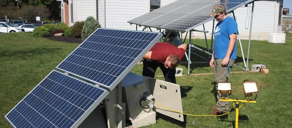 two students working on a solar panel