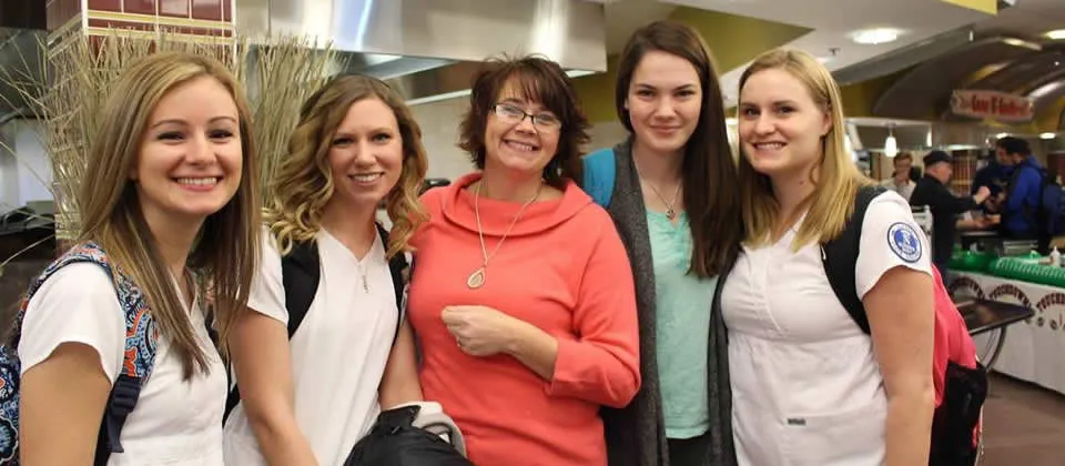 four female nursing students with their professor at the dining hall