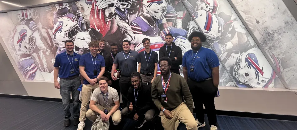 group of students in front of a wall of Buffalo Bills mural