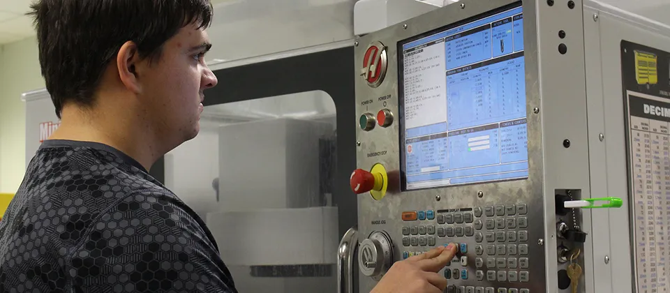 "student pressing buttons on a machine"