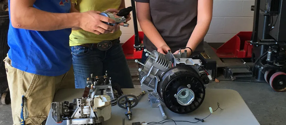 2 students around a table with some motor parts