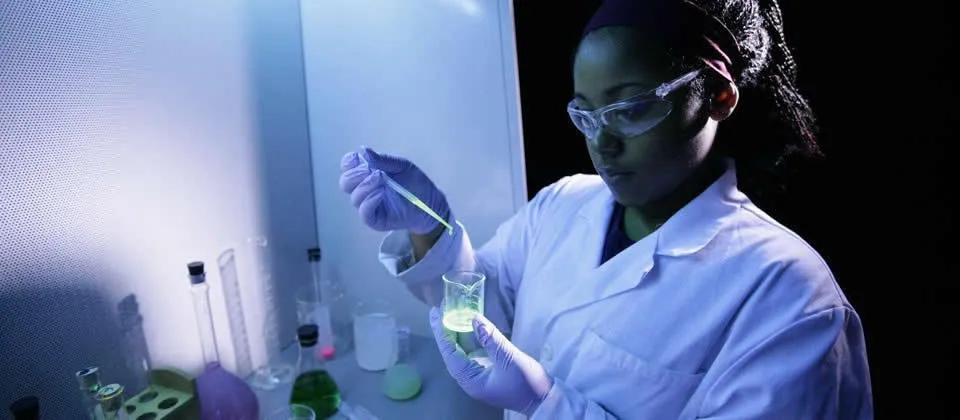 female student with lab coat and safety glasses