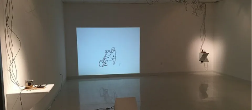 empty room with a drawing on the wall of someone on a segway, wires hanging down on the walls