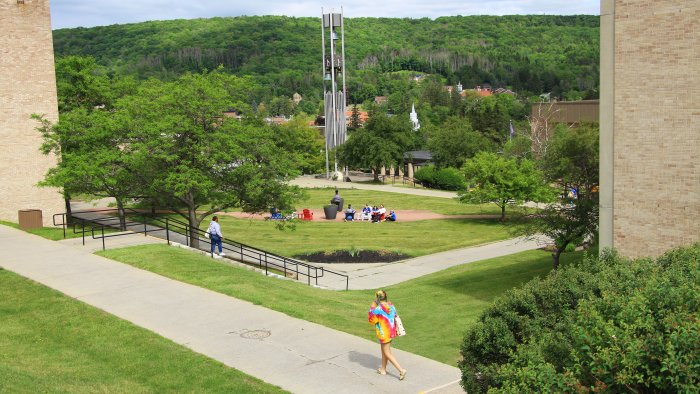 Students enjoying a sunny day by the bell tower before orientation