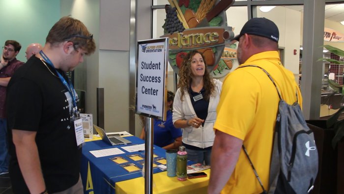 Students and parents asking questions at Orientation resource tables