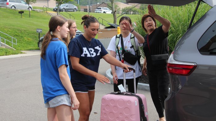Sisters of ABX helping a new student move into their dorm.