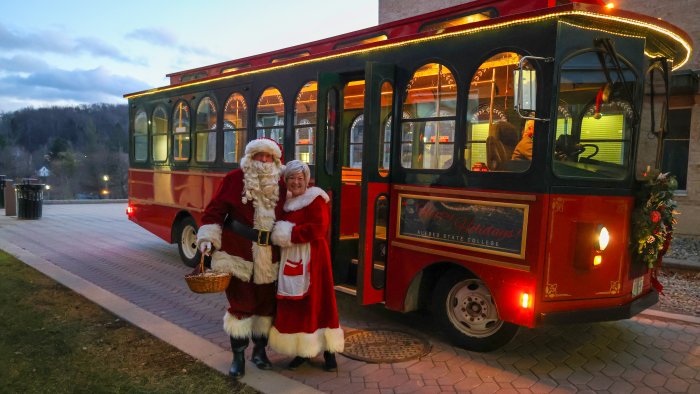 Santa and Mrs. Claus pose with the new trolley.