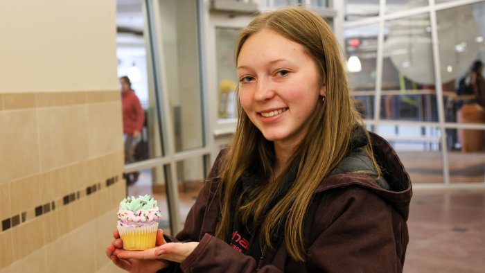 Female student poses with the cupcake she decorated