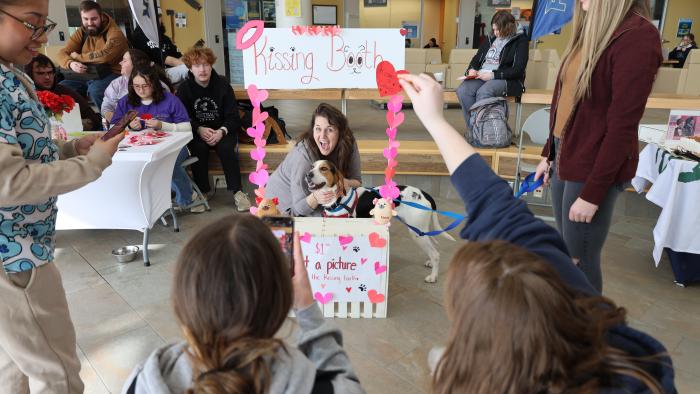Staff member participating in dog kissing booth