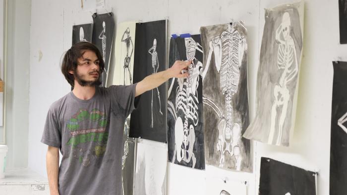 Student presents his artwork in class