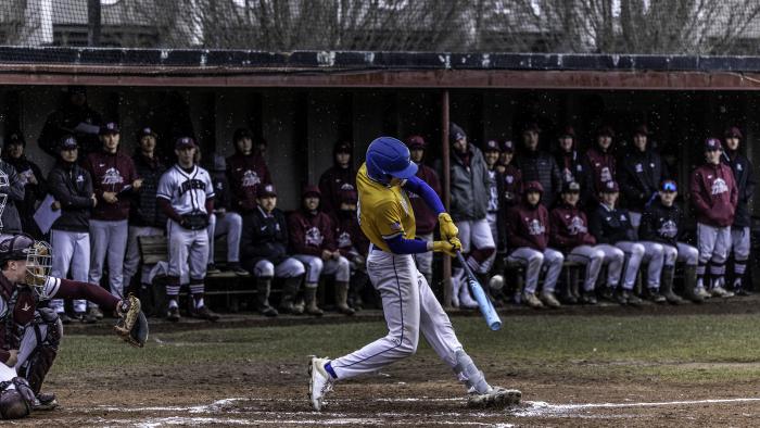 Alfred State player hits the ball.