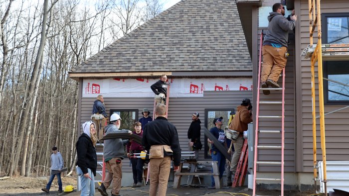 Students put siding on house in Wellsville.