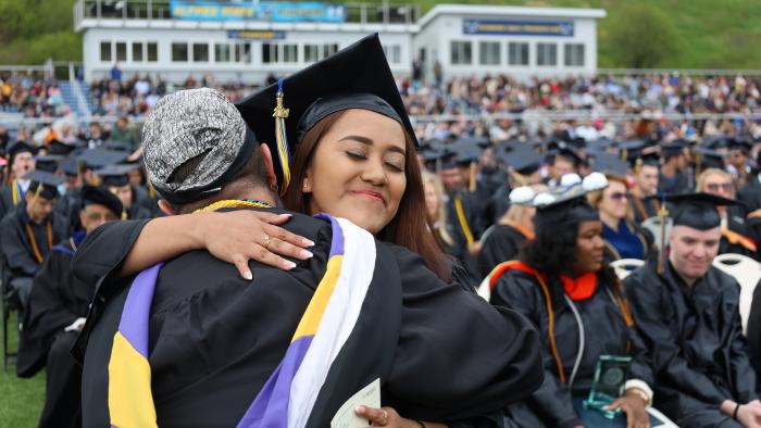 Student hugs professor at Commencement