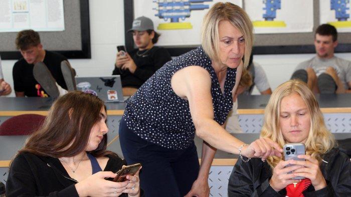 A pair of Alfred State students work with Professor Susan Gorman in a marketing class.