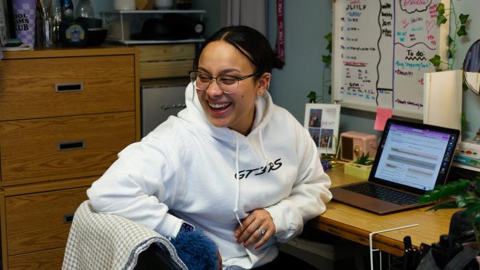 Student Angie Jimenez has a laugh in her dorm.