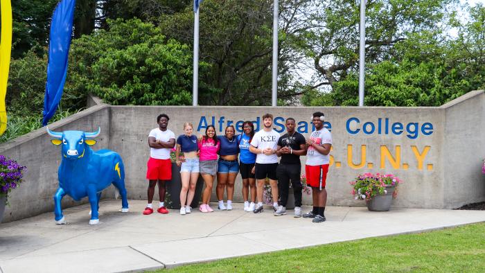 Orientation Leaders pose at main entrance to Alfred State 