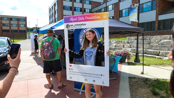 Student poses for a photo at orientation