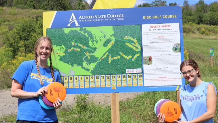 Students pose near the new disc golf course