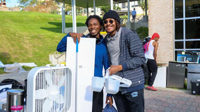 Students pose with items bought at Mega Sale