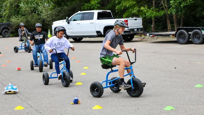Students try out Mario Kart on tricycles