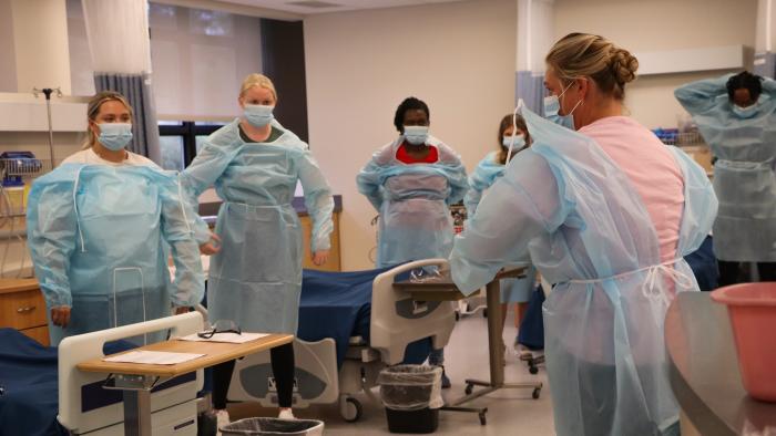 Nursing students learning how to put on PPE