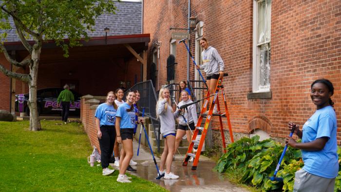 Womens lacrosse players washing windows