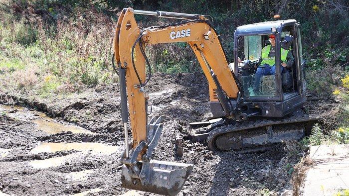 Heavy Equipment Operations student helping clear a flood affected area