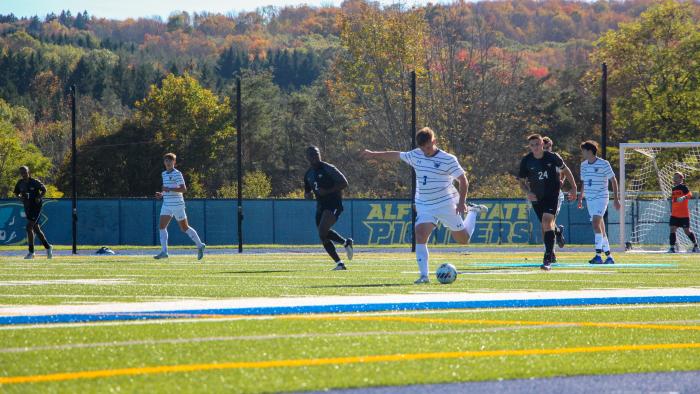 Alfred State Men's soccer player kicks ball