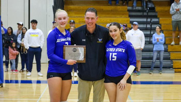 Athletic Director and student athletes with AMCC Regular Season Champions plaque
