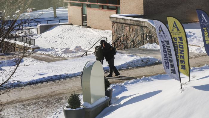 Two students hug each other on campus