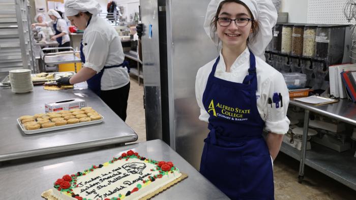 Baking student poses with her Douglass Day cake