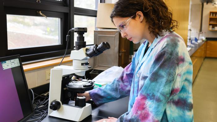 Female student using a microscope