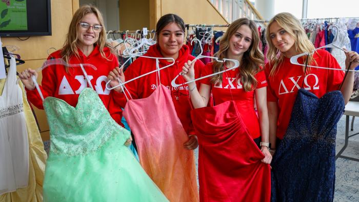 Members of Delta Chi Omega pose with prom dresses