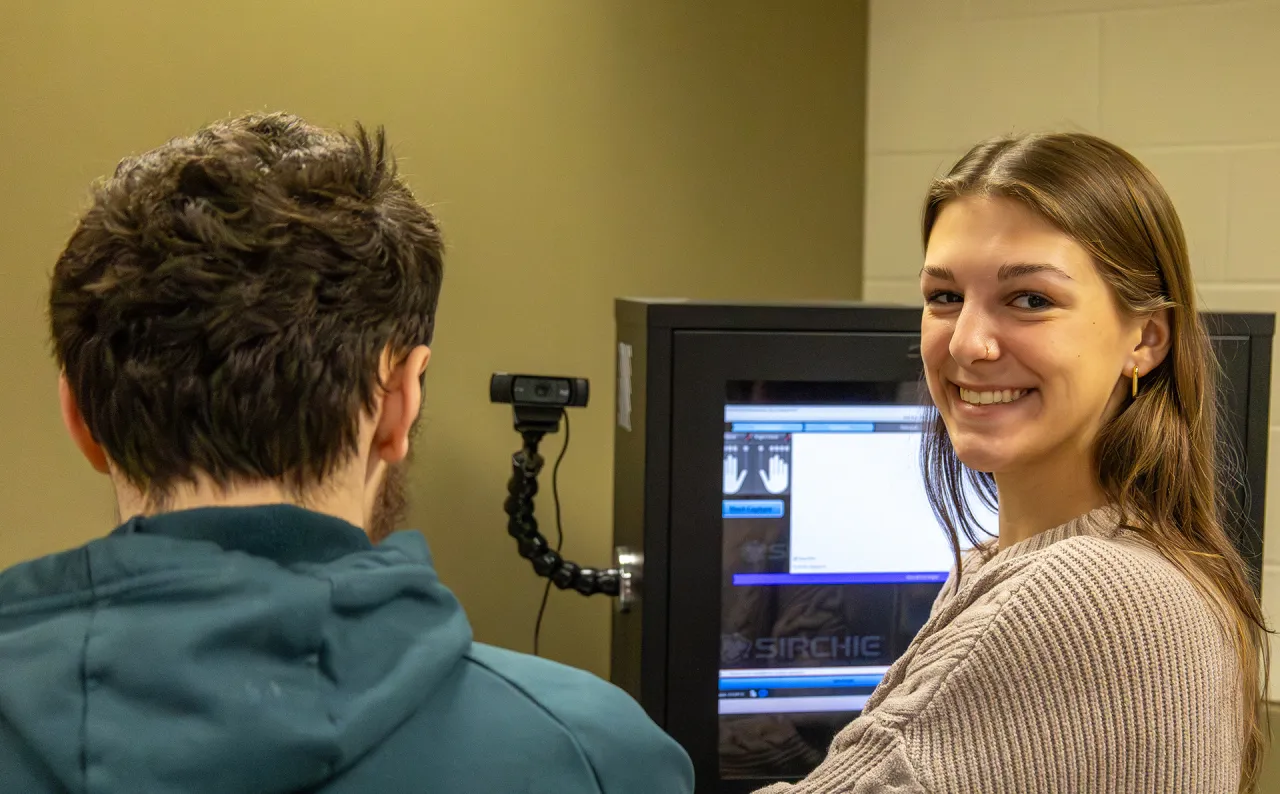 student takes finger prints of another student in a lab.