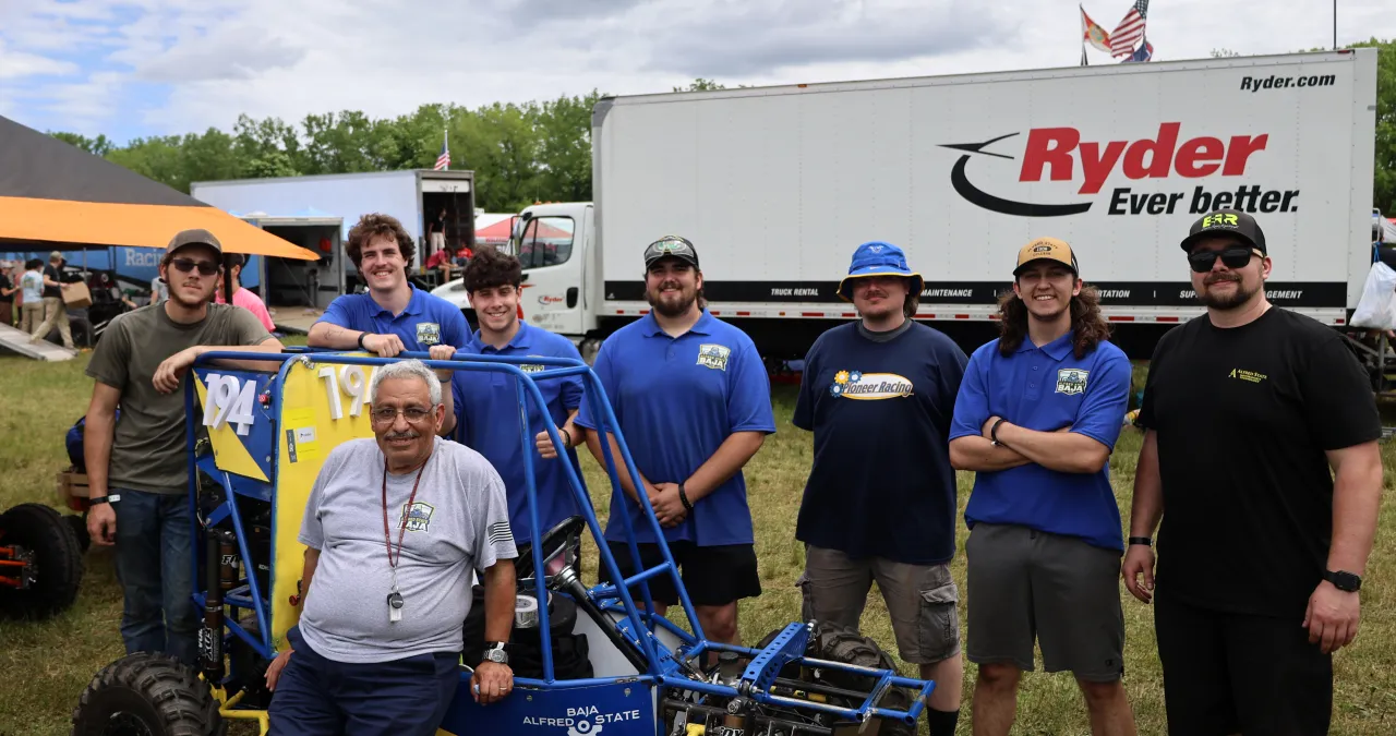 The Alfred State SAE Baja poses in front of their car