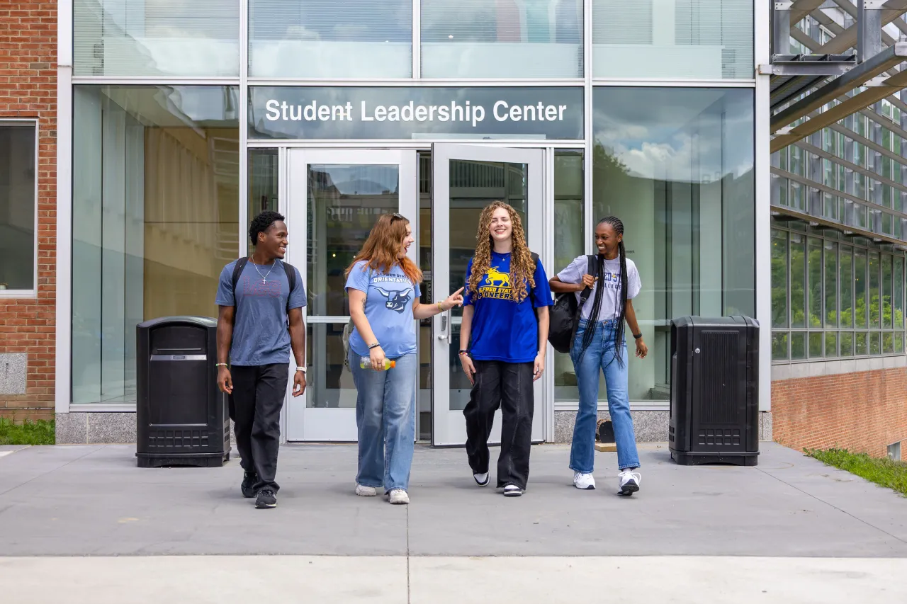 student walk out of the student leadership center smiling and laughing