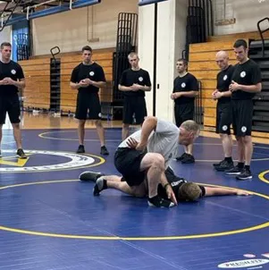 police academy students wrestling on a matt