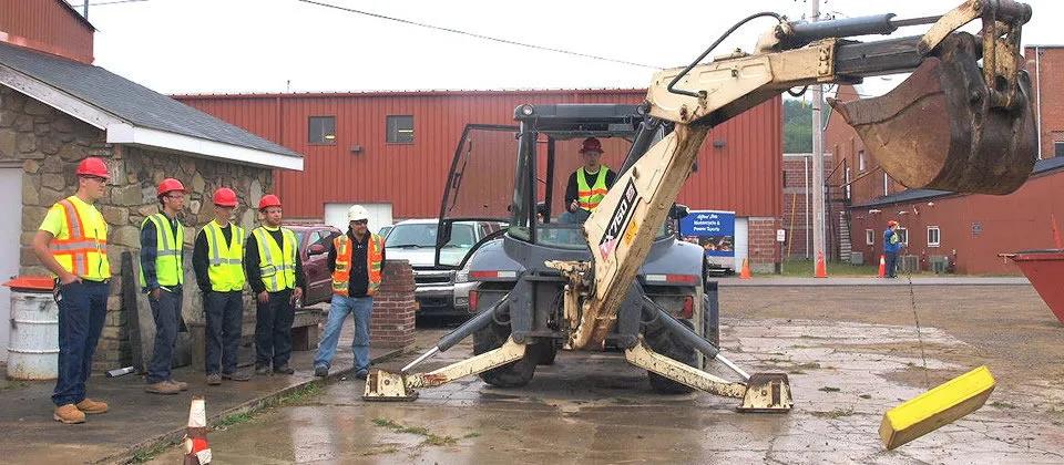 Students outside with excavator.