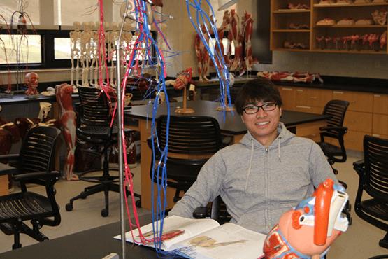 student sitting at a table in a science lab