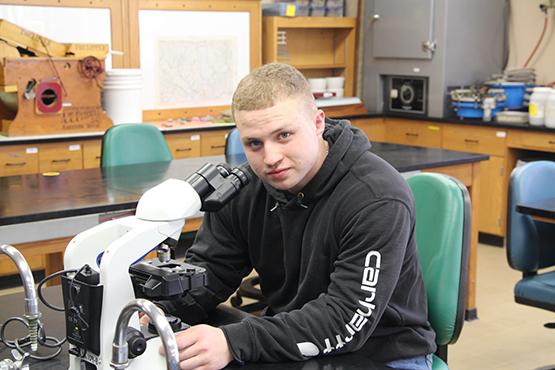 Nathan Martin uses the microscope in a lab