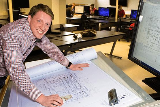 Robert Mahany standing over a drawing on a table