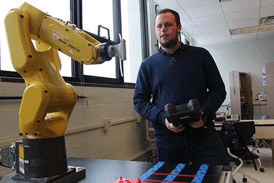 student holding a remote with a piece of equipment