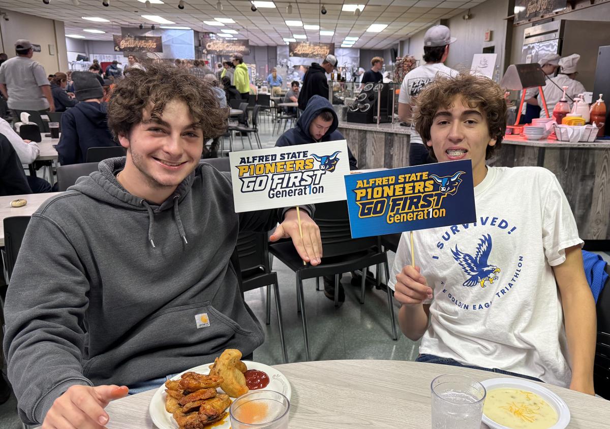 students smiling holding First-Generation student signs