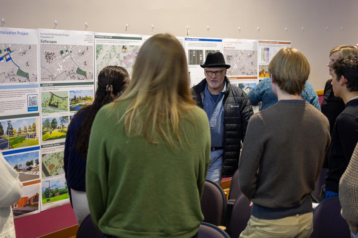 Architecture students speak with a community member at a presentation.