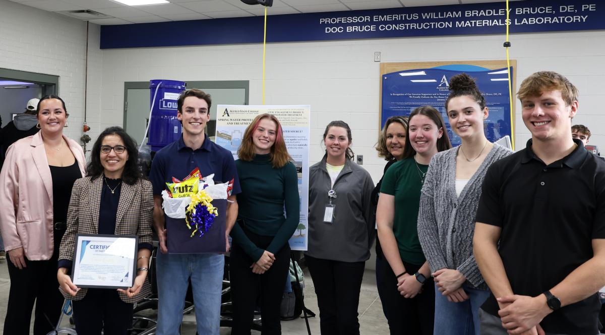 Students pose with their prize for winning a water treatment contest