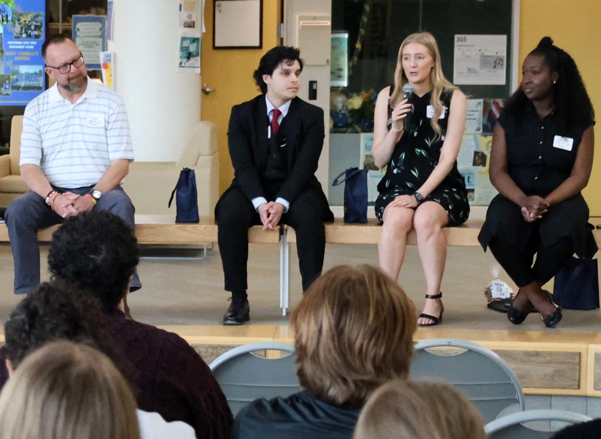 Leyah speaks with current students at a networking event.